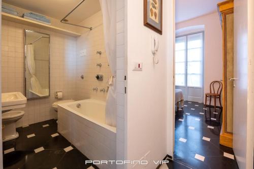 a bathroom with a tub and a toilet and a sink at Martino by PortofinoVip in Portofino