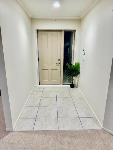 a hallway with a door and a potted plant at Entire House!3Bedroom,2 Bathroom, Fully FencedYard in Wallaceville