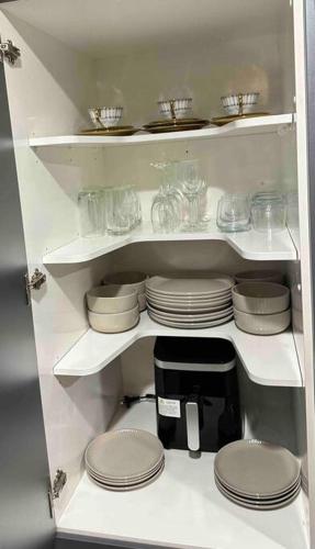 a white shelf with plates and glasses on it at Entire House!3Bedroom,2 Bathroom, Fully FencedYard in Wallaceville