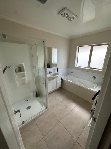 a bathroom with a shower and a tub and a sink at Entire House!3Bedroom,2 Bathroom, Fully FencedYard in Wallaceville