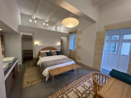 a bedroom with a bed and a bench in it at Authentic Maltese Boutique Holiday Home with Rooftop Pool - Moon Townhouse in Cospicua
