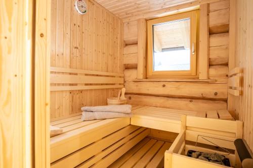 a wooden sauna with a bench and a window at Naturzeithof in Hirschegg