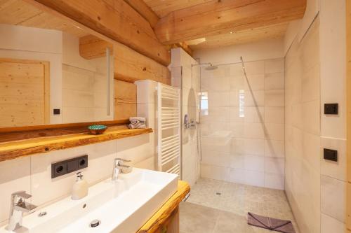 a bathroom with a white sink and a shower at Naturzeithof in Hirschegg