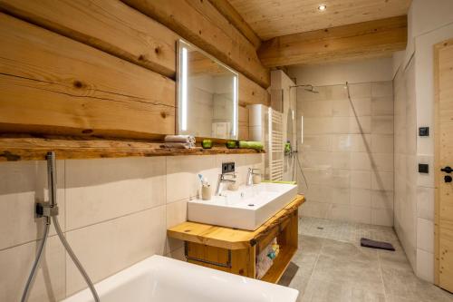 a bathroom with a sink and a bath tub at Naturzeithof in Hirschegg