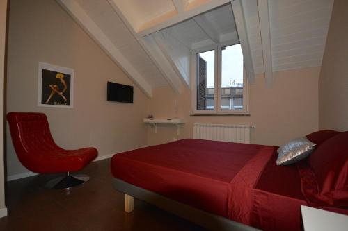1 dormitorio con cama roja y silla roja en B&B Leonardo, en Rho