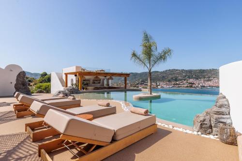 a pool with chaise lounges and a resort at Evlalia Studios & Villas in Skopelos Town