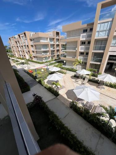 a patio with umbrellas and tables and chairs and buildings at Apartment in Playa Nueva Romana in San Pedro de Macorís