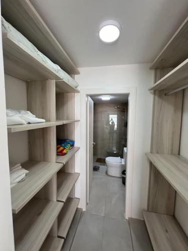 a bathroom with wooden shelves and a toilet at Apartment in Playa Nueva Romana in San Pedro de Macorís