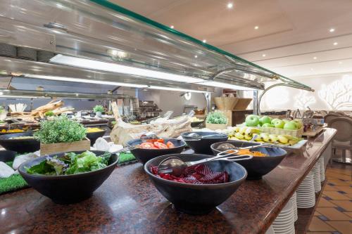 a buffet line with bowls of fruits and vegetables at Praia D'El Rey Marriott Golf & Beach Resort in Casal da Lagoa Seca