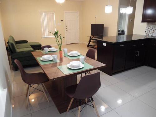 a living room with a wooden table and chairs at Heights at Mcoll Luxury Condo #2 in McAllen
