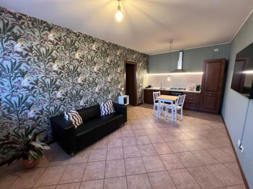 a living room with a black couch and a kitchen at La Trinità in Bovo