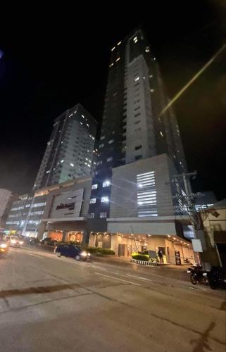two tall buildings in a city at night at Avida Tower 2 Mountain View Condominium in Davao City