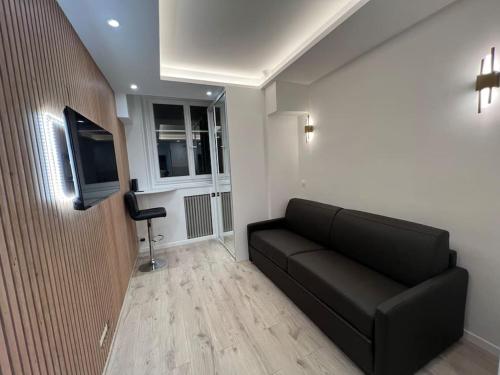 un salon avec un canapé et une télévision à écran plat dans l'établissement Appartement de luxe PARIS 16, à Paris