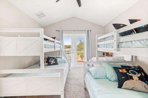 a bedroom with white bunk beds and a couch at 4BD 3BR Pool Paradise 1 mile from Beach & Downtown in Saint Augustine