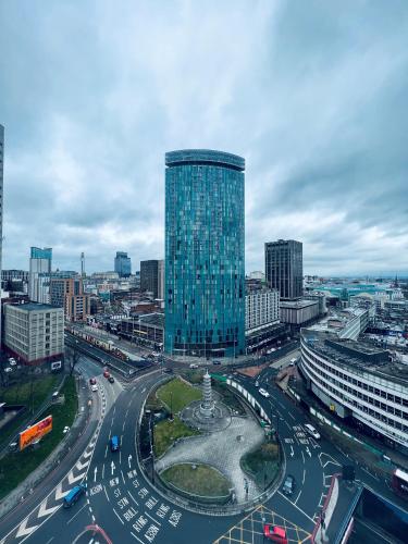 a busy city with a tall glass building and traffic at Radisson Blu Hotel, Birmingham in Birmingham