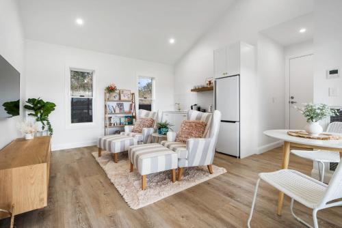 a living room with white walls and a table and chairs at Peaceful & Cosy Studio - Immaculate Presentation in Orange