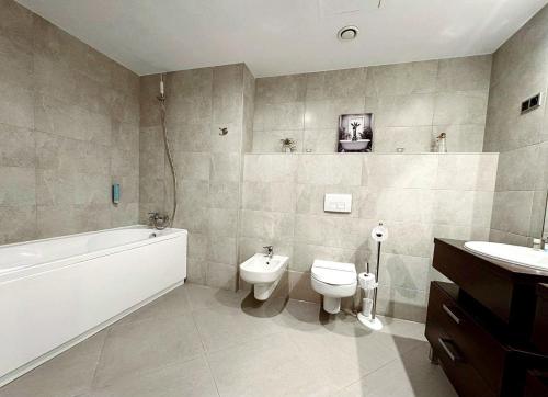 a bathroom with a toilet and a tub and a sink at Apartment "Mountain Relax" in Poiana Brasov