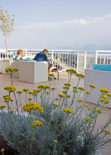 two people sitting on the deck of a ship at BUE MARINO Hotel & Roof Lounge in Cala Gonone