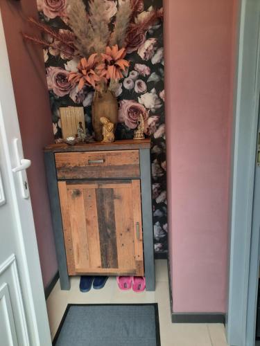 a hallway with a small cabinet and pink walls at Maison touristique à Bouillon avec jardin in Bouillon