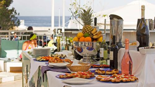 uma mesa com pratos de comida e garrafas de vinho em BUE MARINO Hotel-Restaurant-Cocktail Bar em Cala Gonone