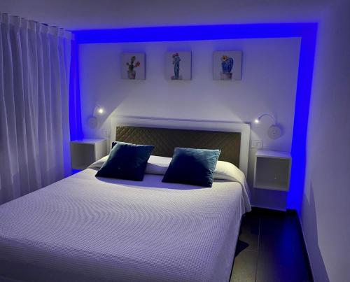 Un dormitorio con una cama con luces azules. en La Caletta Casa Vacanze, PRIVATE POOL, en Terrasini