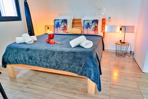 a bedroom with a large bed with a blue blanket at Magnifique appartement MISIK vue sur mer, piscine in Case-Pilote