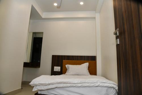 a bedroom with a bed with a wooden headboard at Hotel Shreeji Palace in Ābu Road