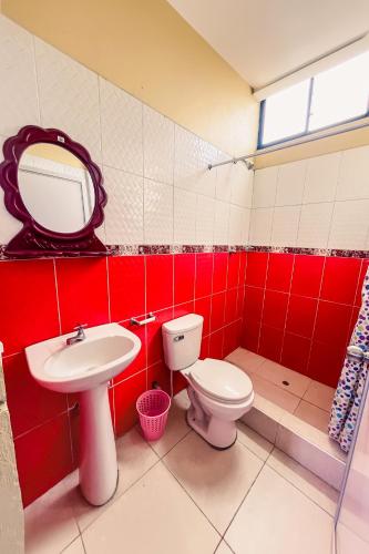 a bathroom with a toilet and a sink and a mirror at Hospedaje Las Amazonas in Iquitos