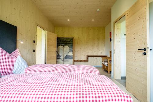 a bedroom with a large bed with a red checkered blanket at Naturzeithof in Hirschegg