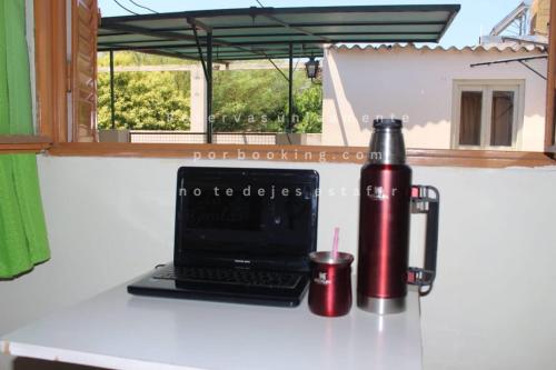 a laptop computer sitting on a counter with a thermos at Alojamientos en Cosquín in Cosquín