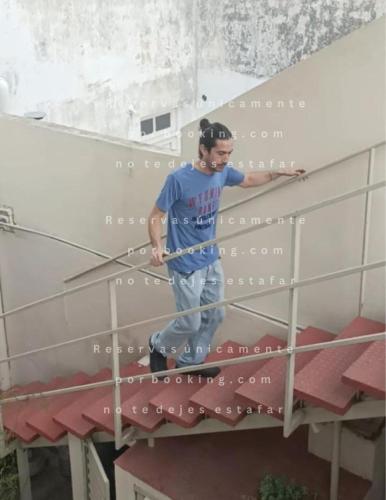 a man standing on top of a building with a pole at Alojamientos en Cosquín in Cosquín