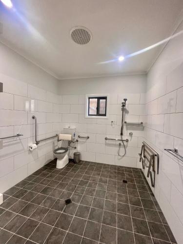 an empty bathroom with a toilet in a room at Cooper's Cottages in Lightning Ridge