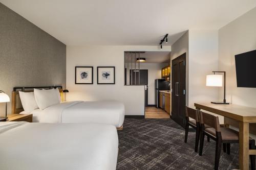 a hotel room with two beds and a desk at TownePlace Suites by Marriott Memphis Germantown in Memphis