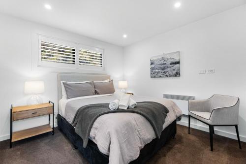 a bedroom with a bed with a chair and a desk at Penthouse with Marina Views - Studio or Two Bedroom Apartment in Wanaka