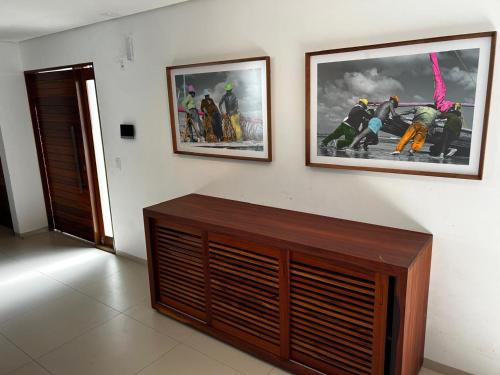 a room with two framed pictures on a wall at Apartamento Chique frente ao mar in Flecheiras