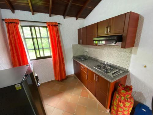 a kitchen with wooden cabinets and a stove top oven at RANCHO SAN LUIS, Páramo in Páramo