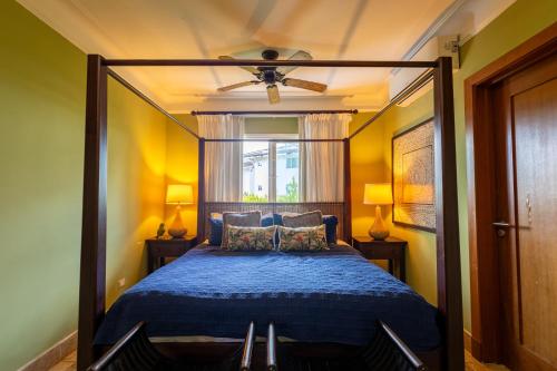 Schlafzimmer mit einem blauen Bett und einem Deckenventilator in der Unterkunft Sunset Cove at Balcones in Las Terrenas