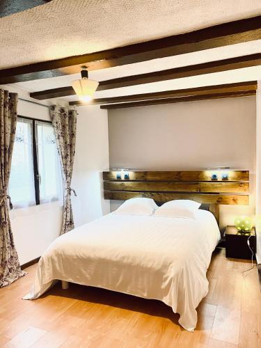 une chambre avec un grand lit avec une tête de lit en bois dans l'établissement Appartement Indépendant avec jardin, entrée autonome par boîte à clé , Self-Check-In, à Saint-Clément