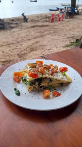 a plate of food on a table near the beach at Bong's Guesthouse M'Pai Bay in Koh Rong Sanloem