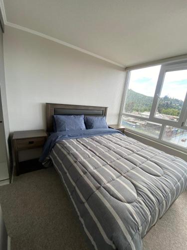 a bedroom with a large bed and a large window at Departamento Condominio Aldunate in Temuco