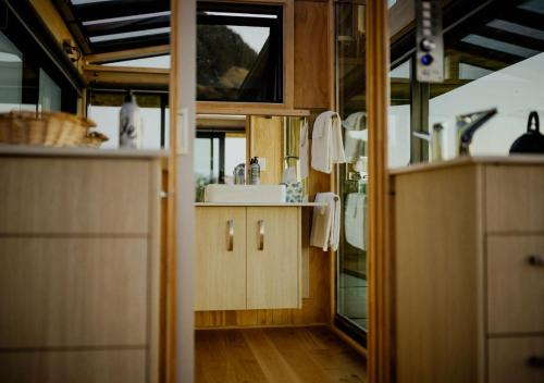 a kitchen with wooden cabinets and a sink at Atatū PurePod in Tormore