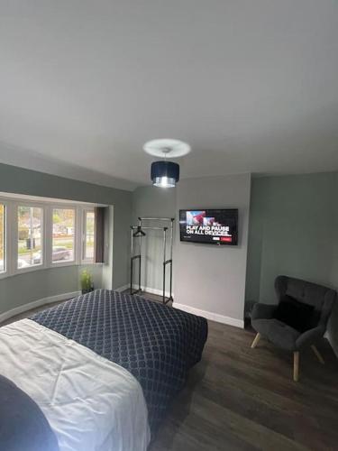 a bedroom with a bed and a chair and a tv at House 246 in Birmingham