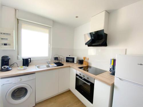 une cuisine avec un évier et un réfrigérateur dans l'établissement Les Dunes 2, à Sangatte