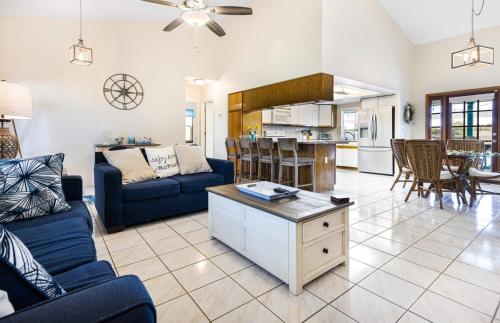 a living room with a blue couch and a kitchen at Lazy Palm Retreat Heated Pool Jacuzzi Gulf Canal in North Fort Myers