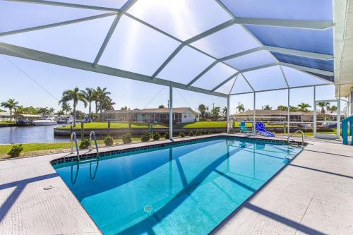 a swimming pool with an umbrella over it at Lazy Palm Retreat Heated Pool Jacuzzi Gulf Canal in North Fort Myers