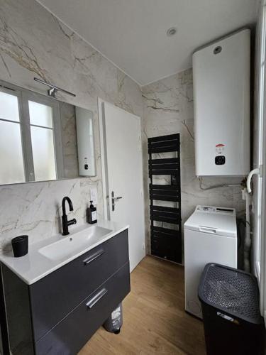 une cuisine avec un évier et un réfrigérateur dans l'établissement Cocon élégant à 10 min de Paris et de La Défense, à Houilles