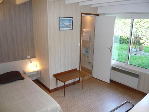 a bedroom with a bed and a table and a window at Guest House La Fauvelaie in Saint-Sylvain-dʼAnjou