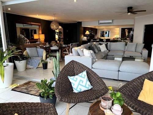 a living room with chairs and a couch and a living room at BEACH GETAWAY! Luxury Beachfront Condo in Punta de Mita! in Punta Mita