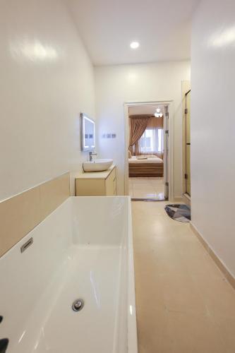 a white bathroom with a tub and a sink at George Residence Osapa, Lekki in Lekki
