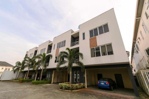 a building with palm trees in front of it at George Residence Osapa, Lekki in Lekki
